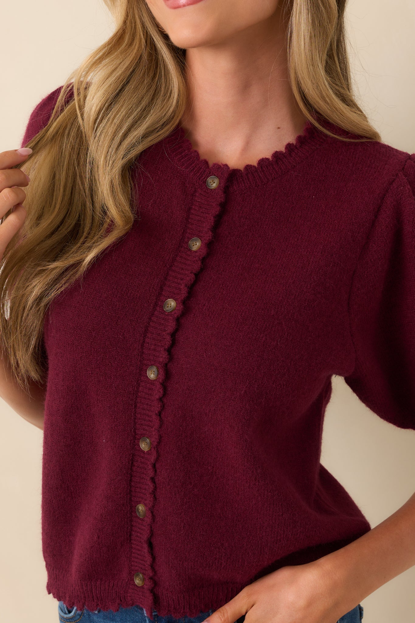 Midsection cropped shot highlighting the button placket and smooth knit texture.