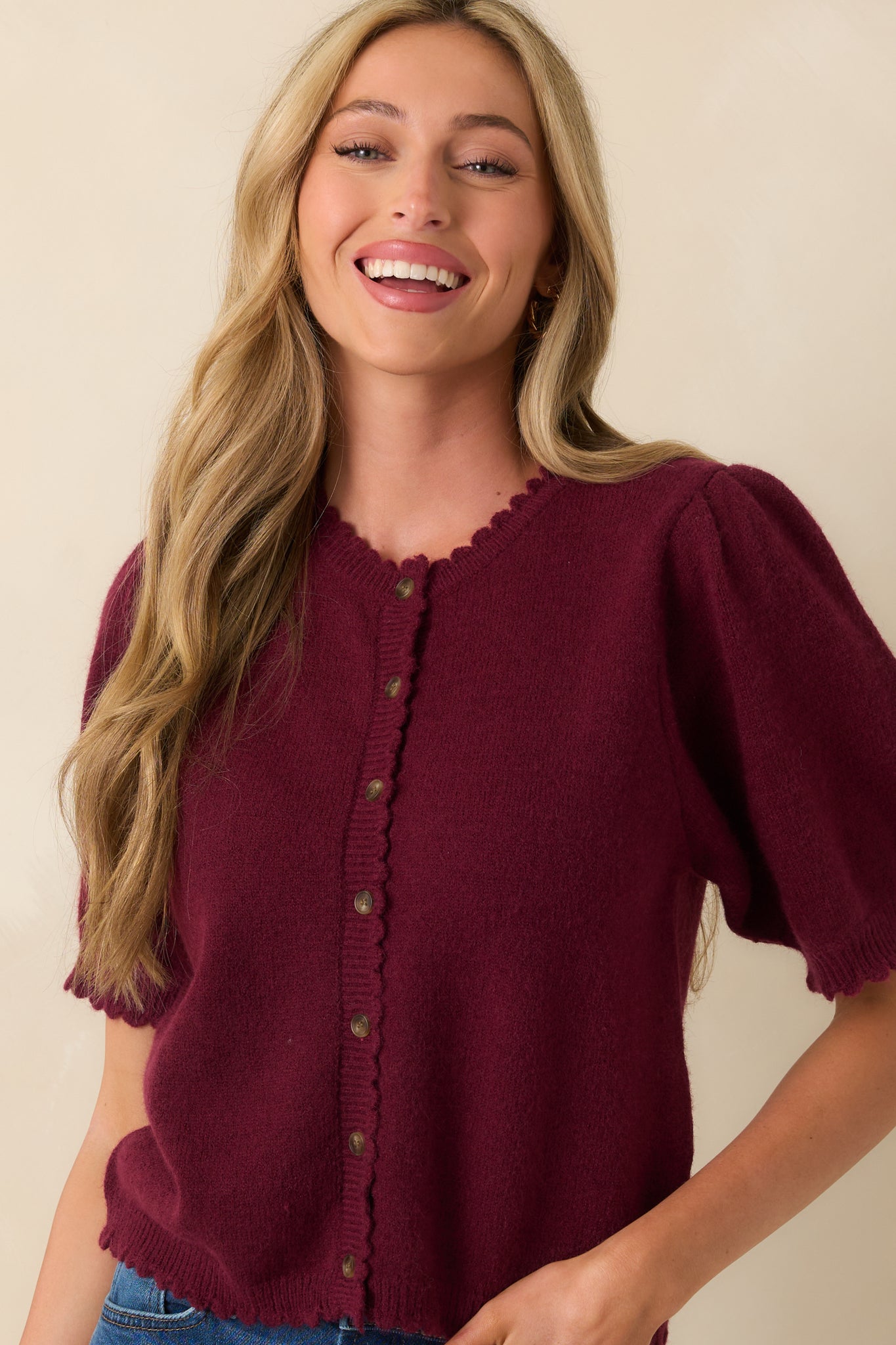Front-facing view of the wine red cardigan showing the round neckline, short puff sleeves, and tortoise shell button front.