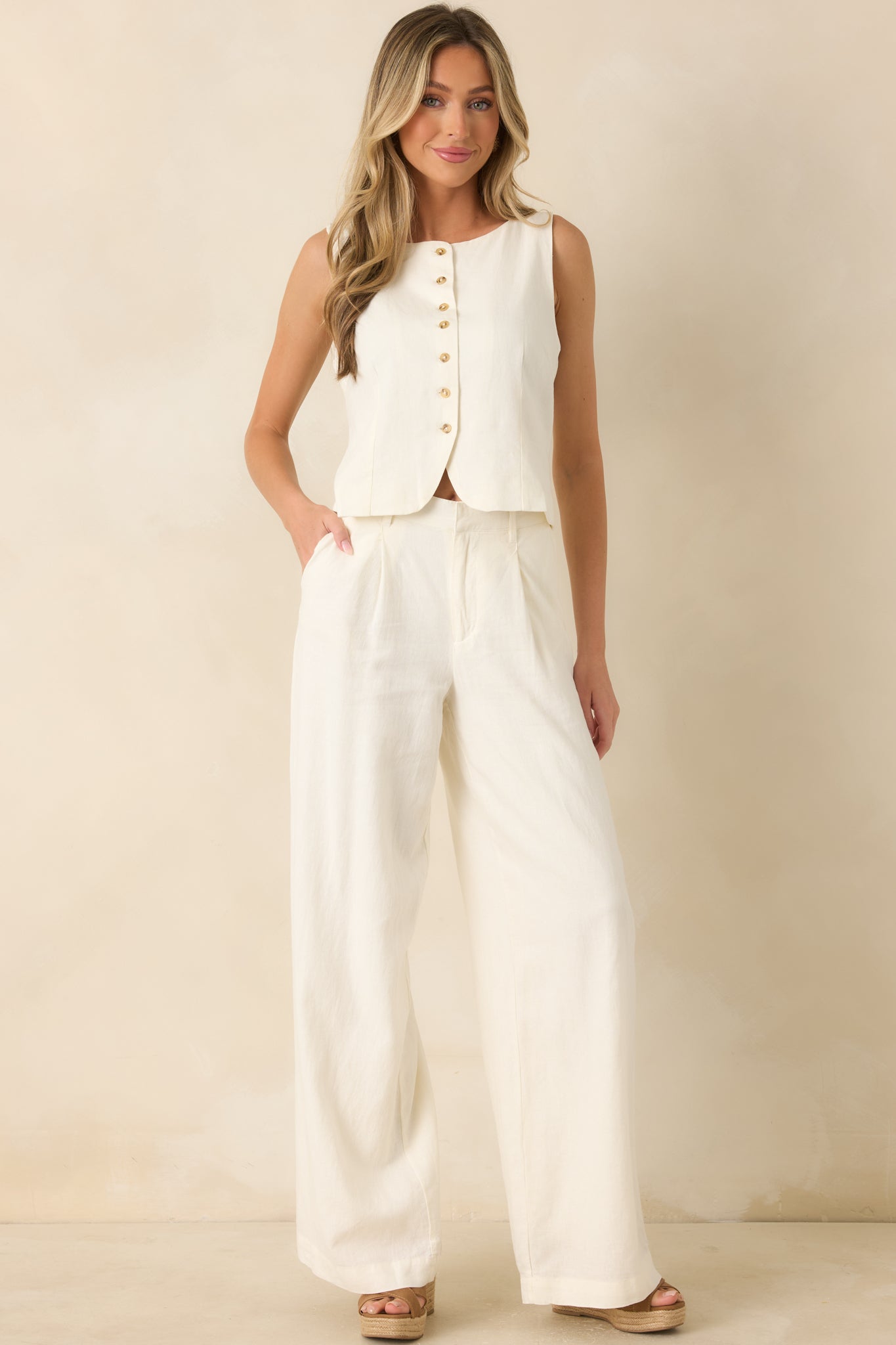 Ivory linen pants showcasing the soft washed texture, comfortable waistband detail, and clean tailored shape.