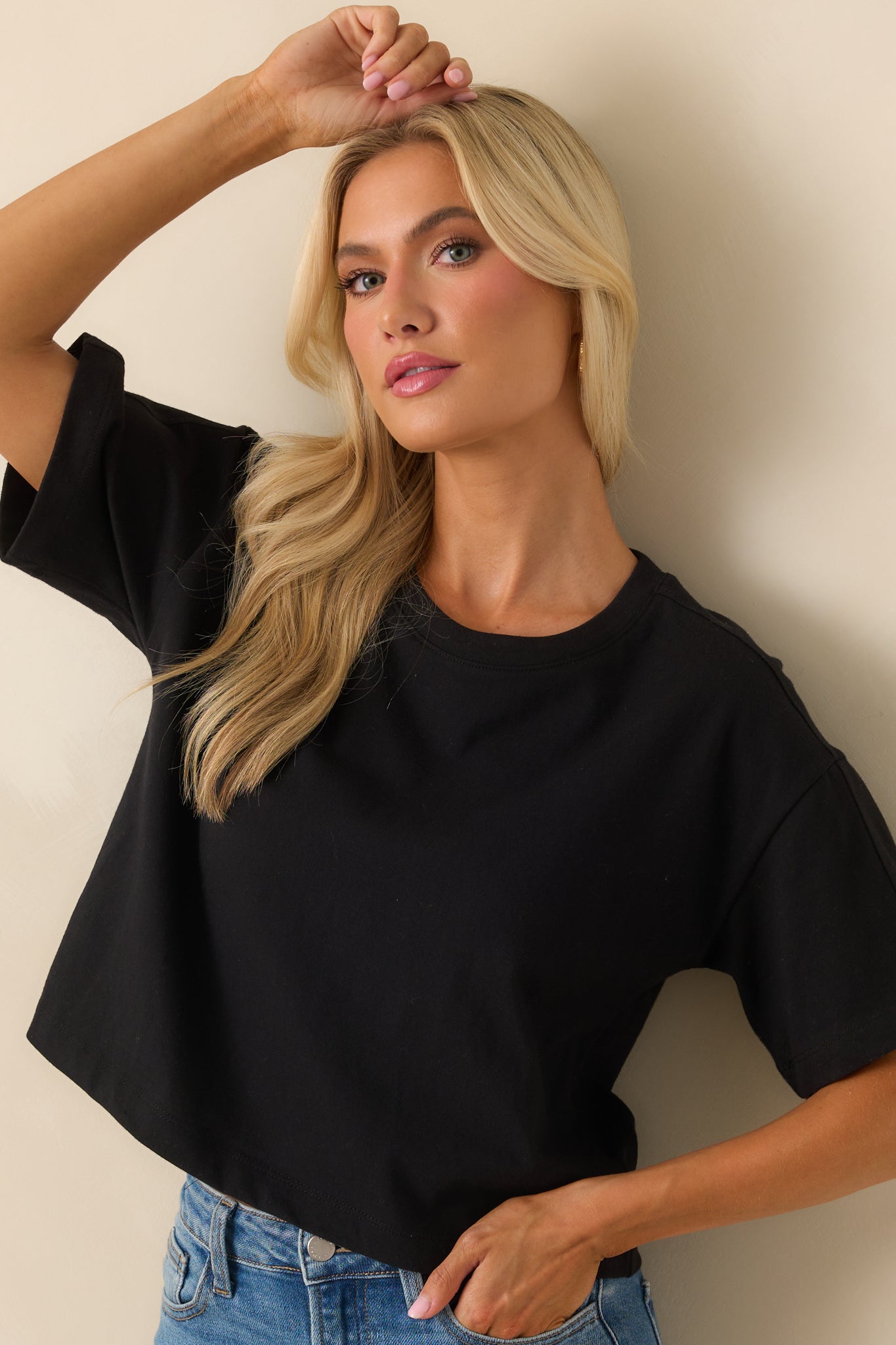 Cropped front view focusing on the crew neckline and upper chest of the black tee.