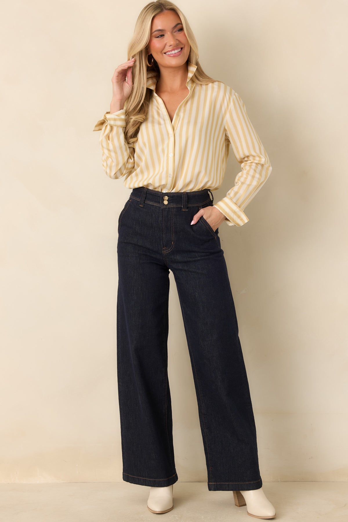 Model wearing Z Supply The Atelier dark wash high-rise denim trousers with wide legs and front pockets.