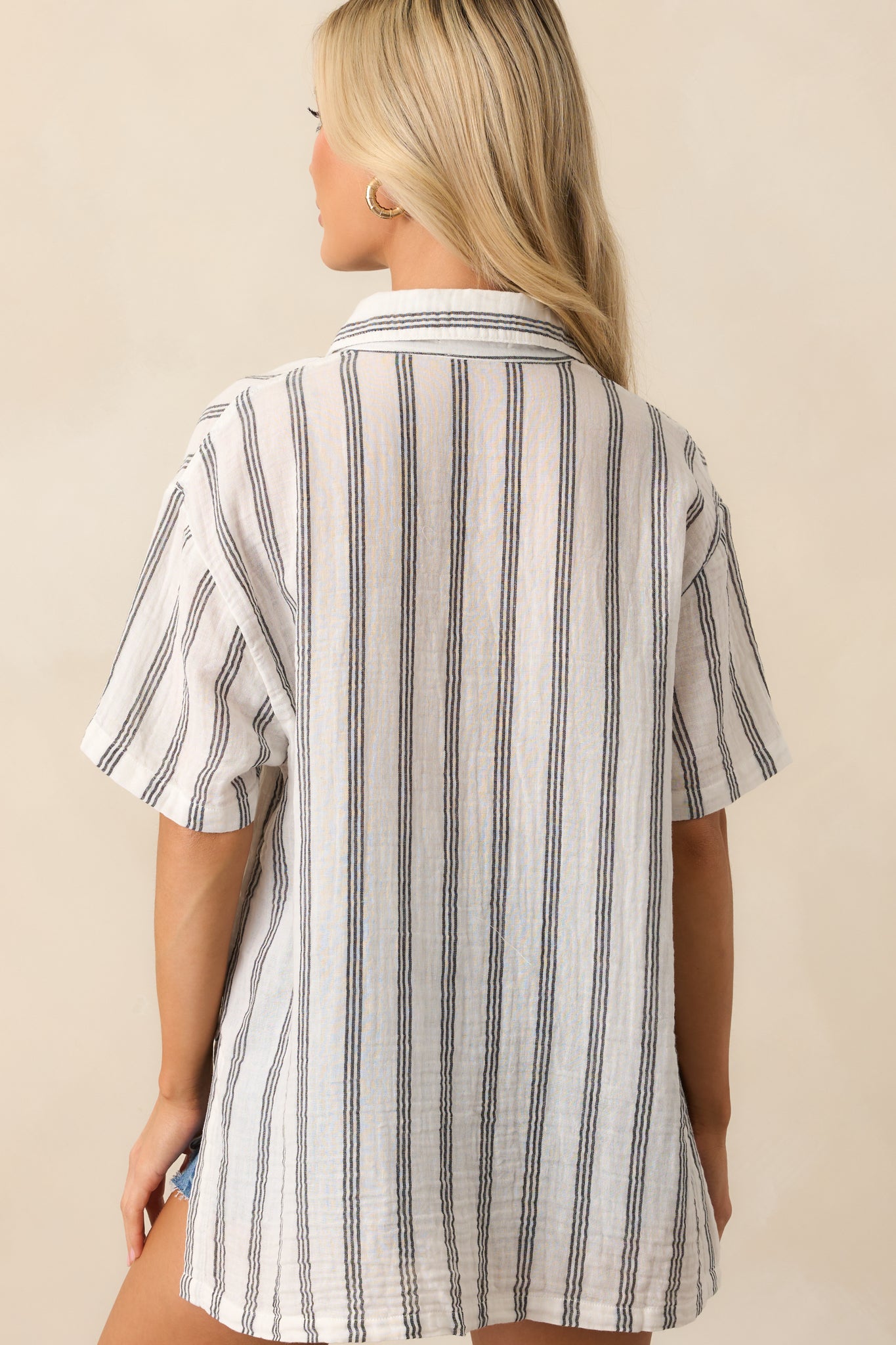 Rear view of the white top with black stripes, showing the relaxed back cut and flow of the lightweight fabric.
