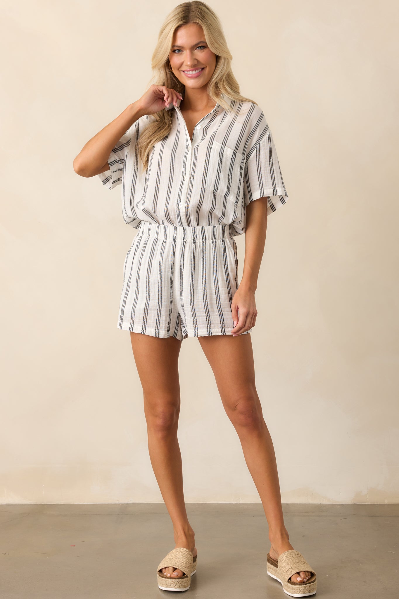 Entire outfit shot highlighting the flowy white cotton shorts with vertical black stripes and elastic waistband.