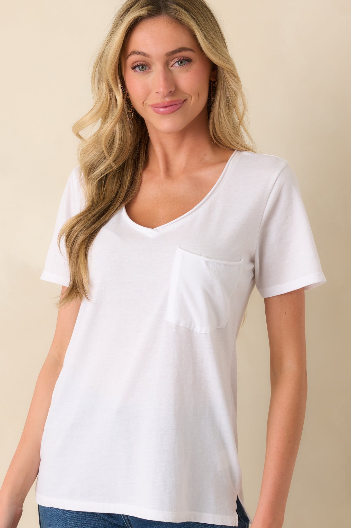 Cropped view of the neckline and upper chest, focusing on the rolled hem finish along the v-neckline.