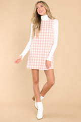 This pink dress features a round neckline, a straight silhouette, and a zipper closure on the back.
