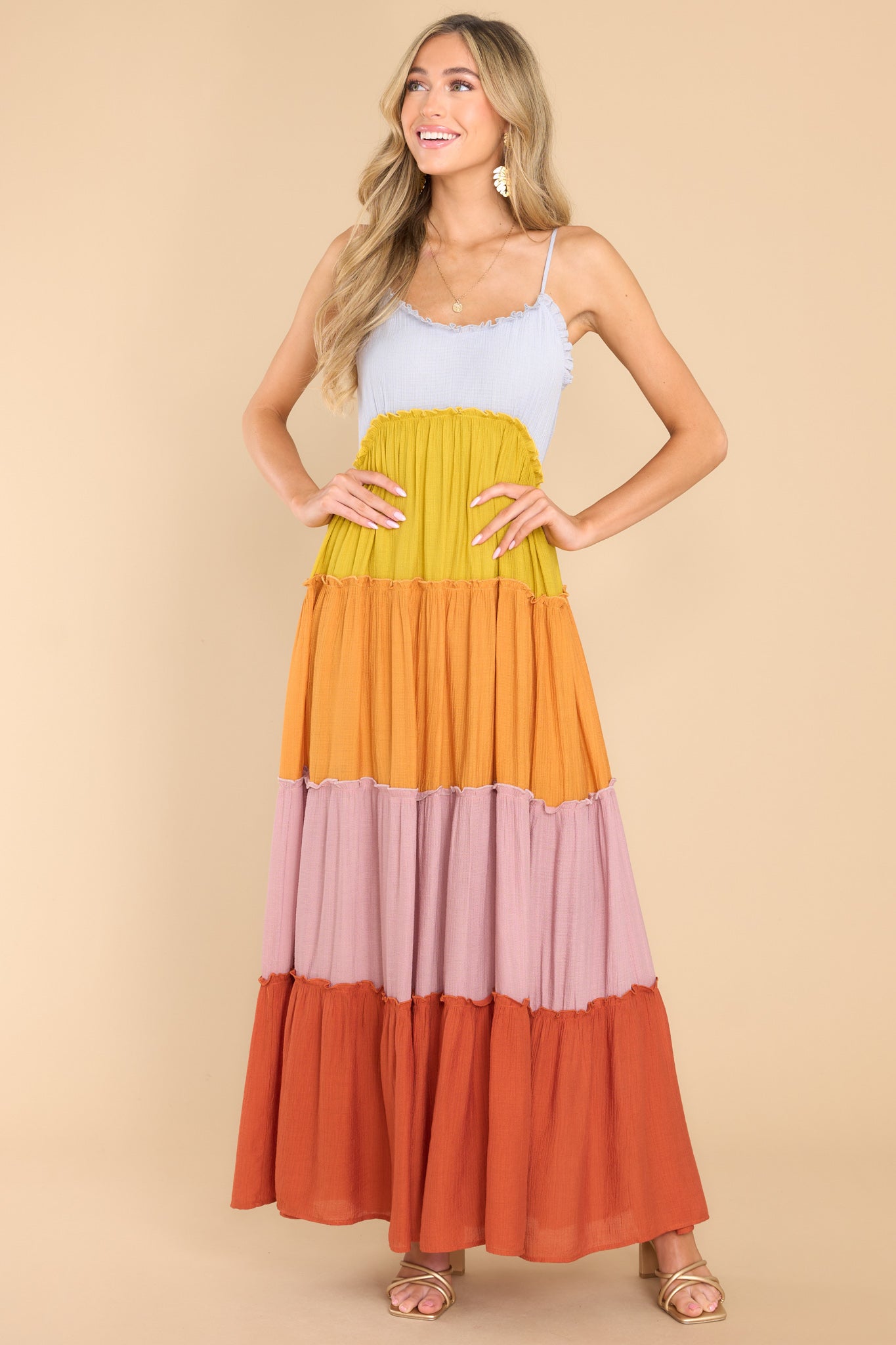 Front view of this dress that features a sweetheart neckline with ruffle detailing, thin adjustable shoulder straps, functional buttons for closure in the back of the bust, and a multicolored, tiered skirt with ruffle detailing.