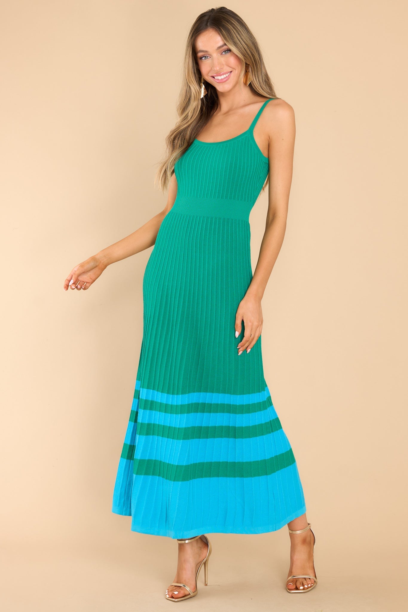 Angled front view of this dress that features a scoop neckline, non-adjustable straps, a ribbed texture, and stretch throughout.