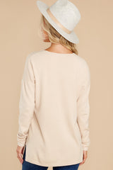 Back view of this sweater that features a v-neckline, long sleeves, seam down the center front, high-low hem with side slits, and a yoked back.