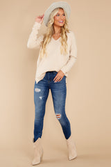 Front view of this sweater features a v-neckline, long sleeves, seam down the center front, and high-low hem with side slits.