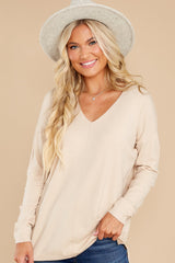 Close up view of this sweater that features a v-neckline, long sleeves, and seam down the center front.