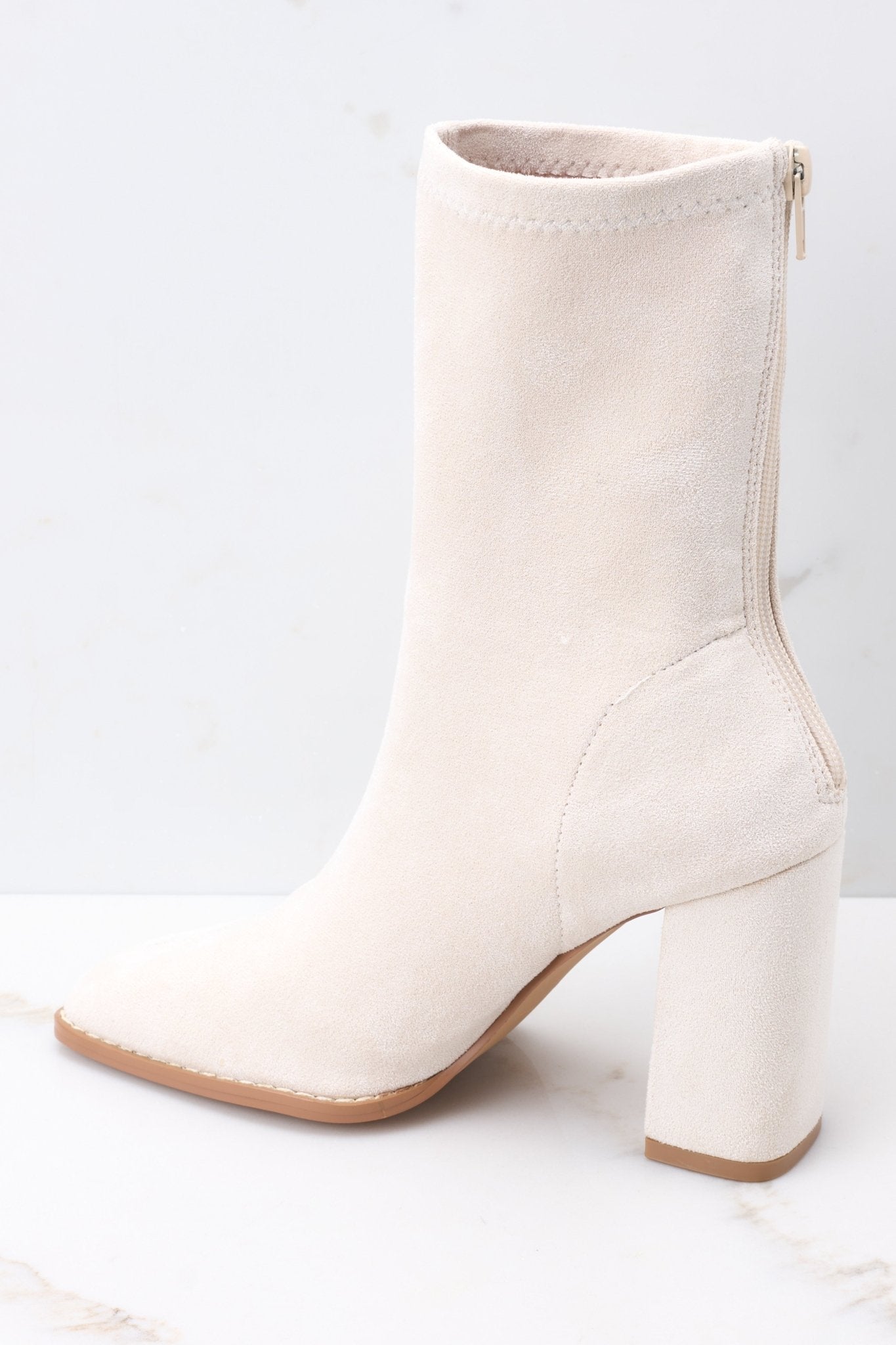 Inside view of ivory booties with a functional zipper down the back, and