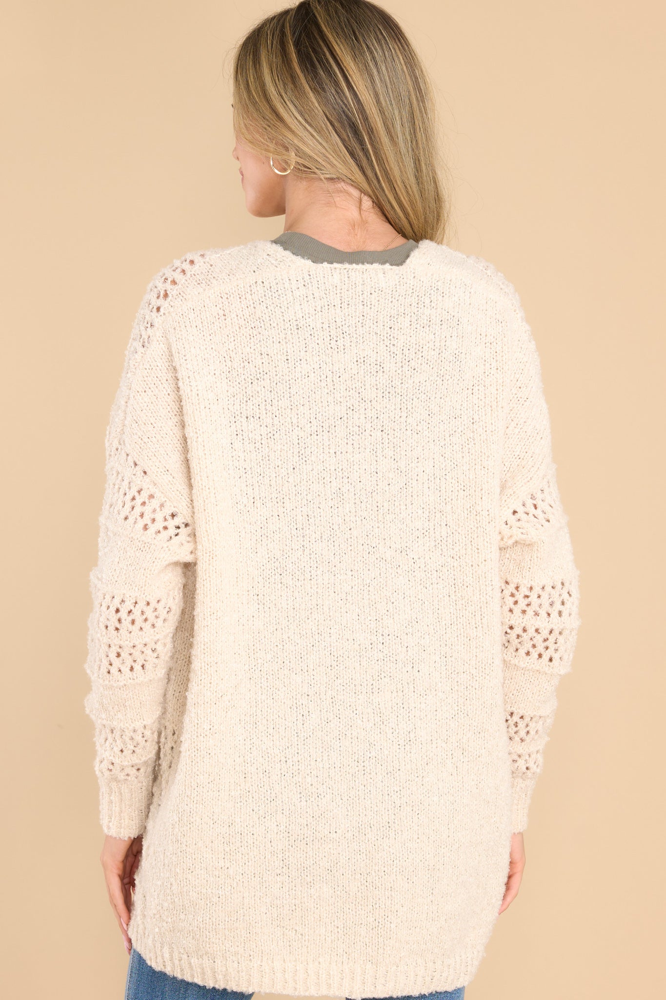 Back view of this cardigan that features a textured design, ribbed detailing, and a soft fabric.
