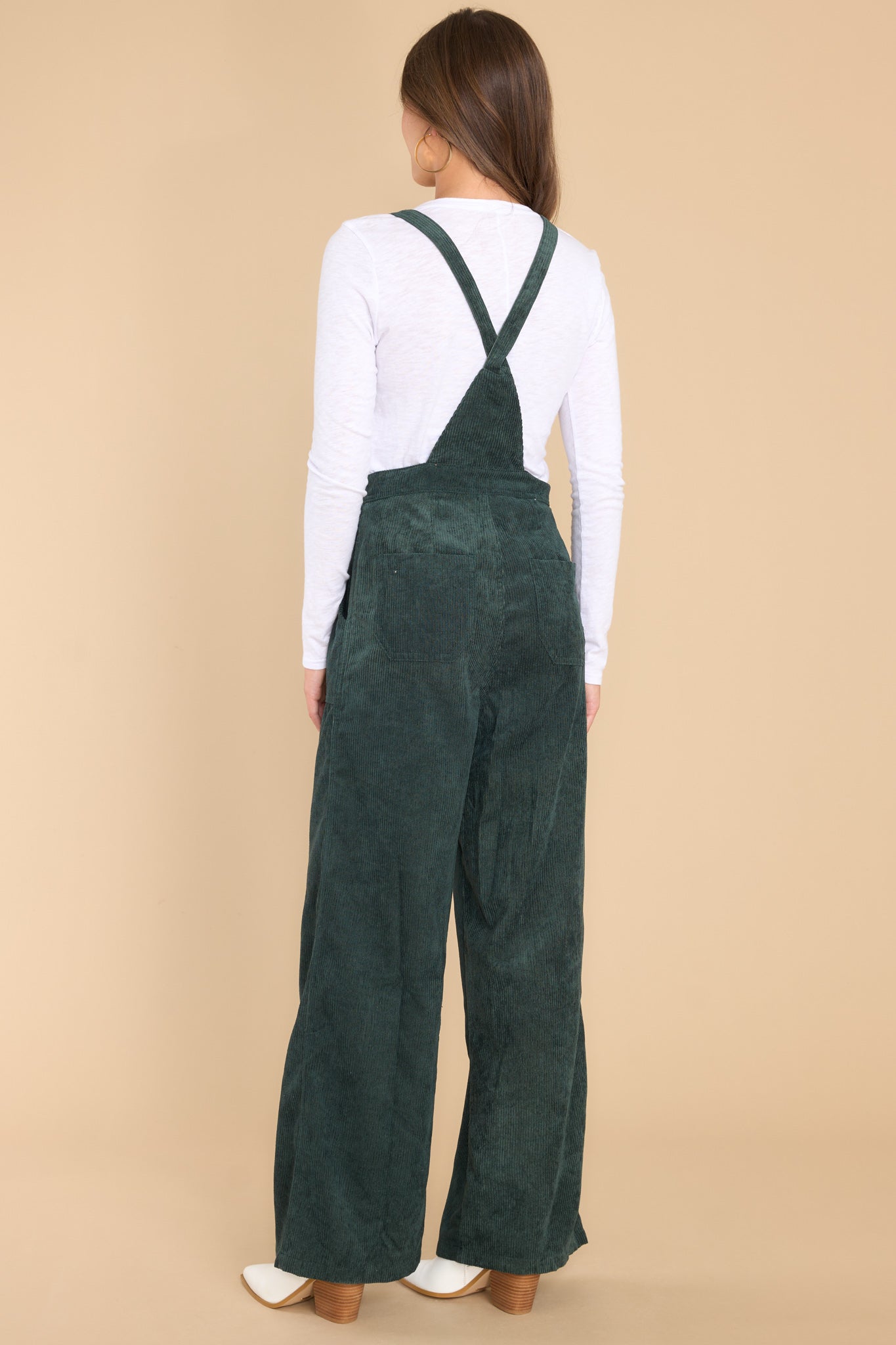 Back view of these overalls that feature adjustable self-tie straps, four functional side pockets and two back pockets, buttons below the bust to allow for a folded look, and a corduroy texture throughout.