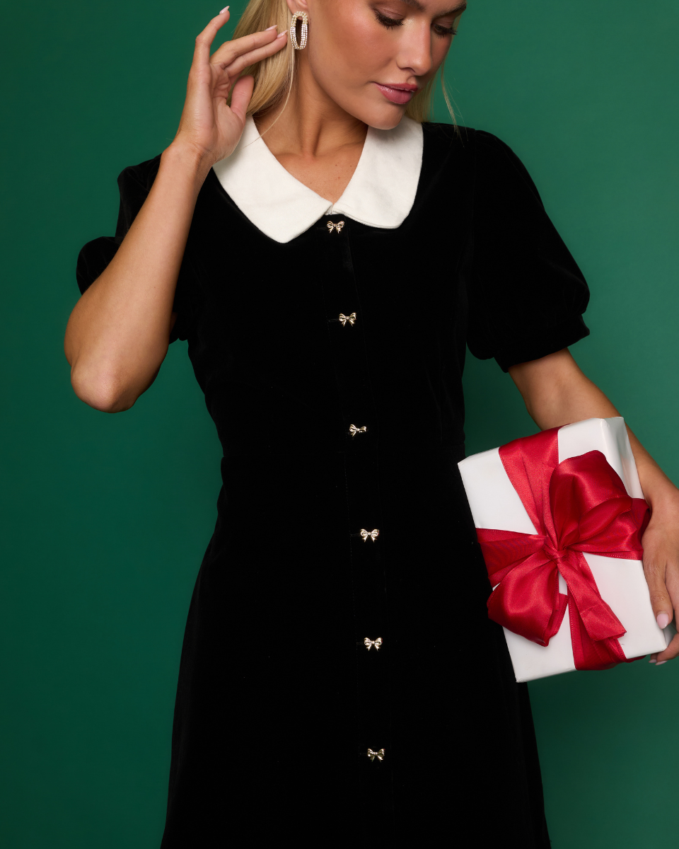 Image of model wearing a black mini dress.