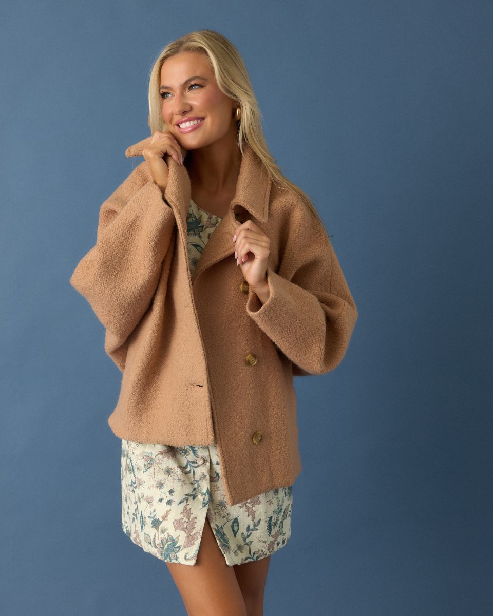 Image of model wearing an ivory and blue floral mini dress with a Camel Brown Single Breasted Wool Blend Coat. 