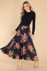 This black dress features a crew neckline, a ribbed sweater bodice and a pleated, floral satin like skirt.