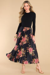 Full body view of this dress that features a crew neckline, a ribbed sweater bodice and a pleated, floral satin like skirt.