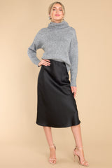 Full body view of this sweater that features a high chunky turtle neck and ribbed detailing on the cuffs.
