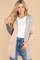 Close up view of this cardigan that features a soft knit fabric and functional pockets.