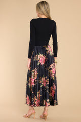 Back view of this dress that features a crew neckline, a ribbed sweater bodice and a pleated, floral satin like skirt.