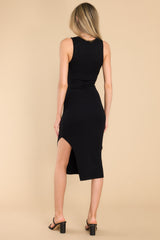Back view of  this dress that features a U-neckline, a slit in the left side reaching the mid-thigh, a bodycon silhouette, and a soft ribbed material throughout.