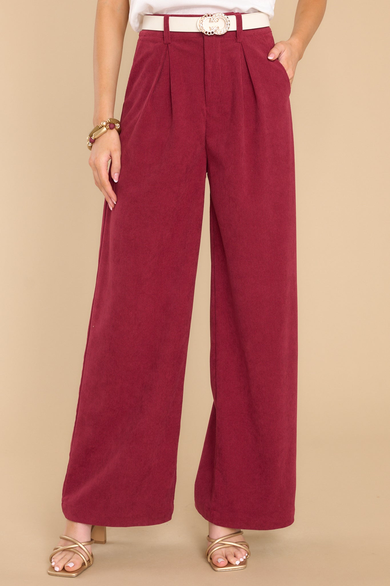 These cranberry colored pants feature a corduroy like material with a zipper hook and eye closure, and two front functional pockets.