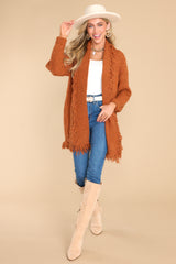 Full body view of this cardigan that features a folded neckline, fringe detailing, and long sleeves with ribbed cuffs.