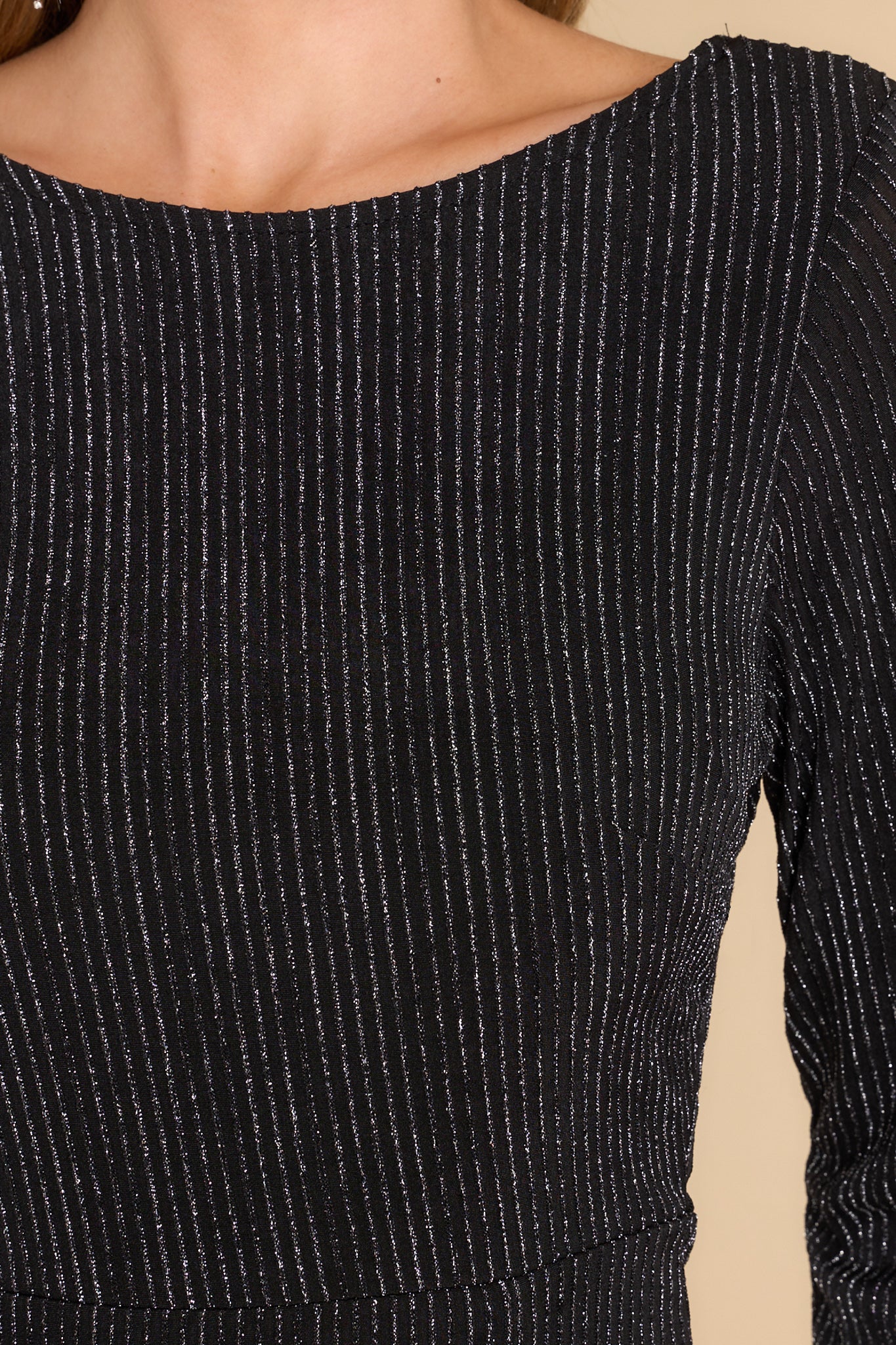Close up view of this dress that features a crew neckline and vertical striped shimmer detailing.