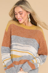 This multi-colored soft sweater features a crew neckline, ribbed cuffs, and an oversized fit.