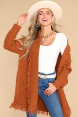 Front view of this cardigan that features a folded neckline, fringe detailing, and long sleeves with ribbed cuffs.