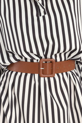 Close up view of this dress that features a crew neckline, dropped shoulders, functional buttons, hip pockets, a functional belt, elastic cuffed long sleeves, and a split hemline.