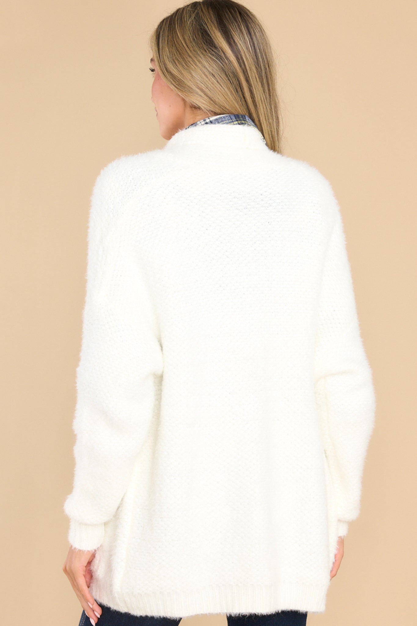 Back view of this cardigan that features two functional pockets on the front, balloon sleeve style, and has an intended oversized fit.
