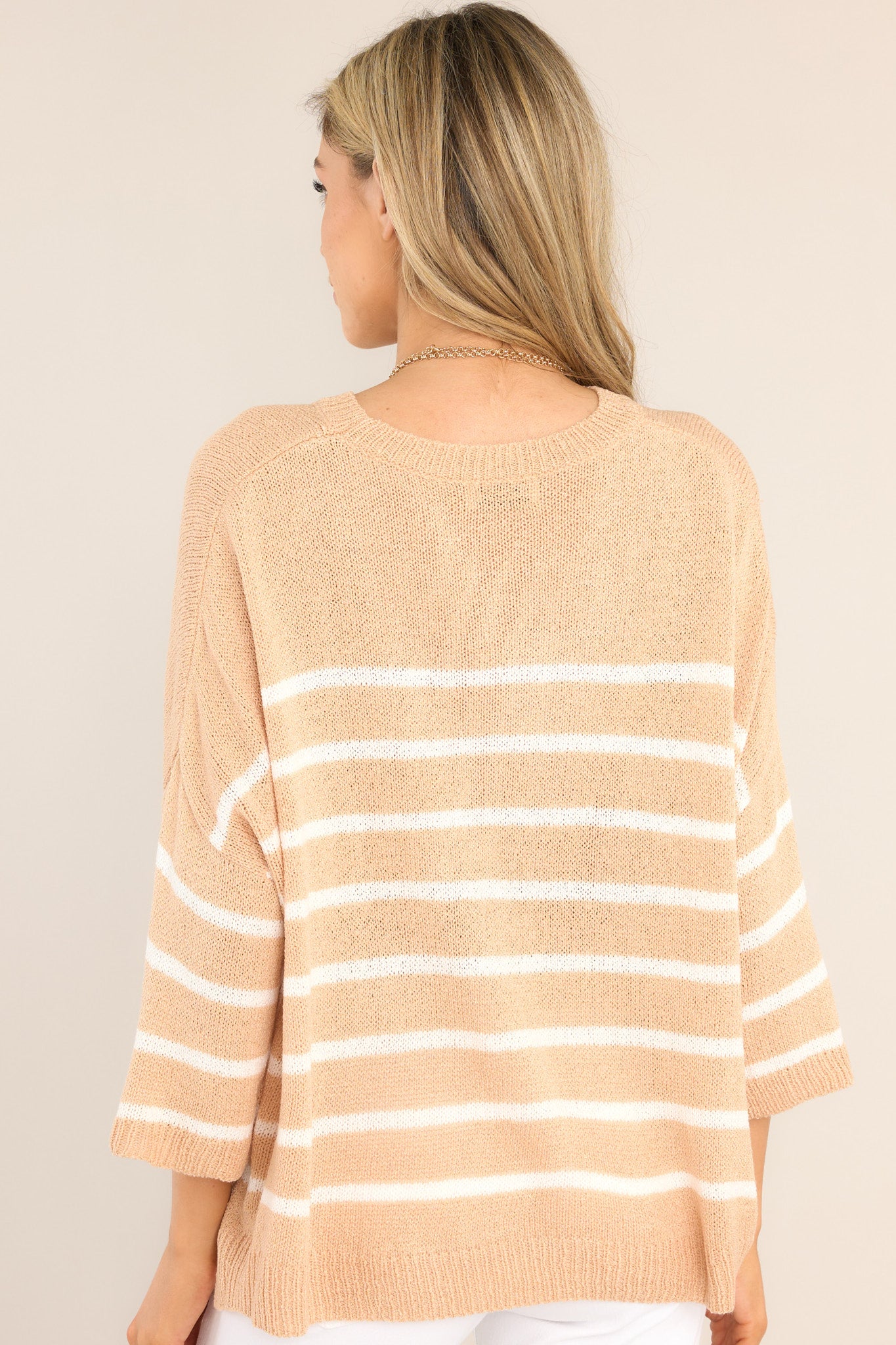 Back view of this top that features a ribbed crew neckline, dropped shoulders, 3/4 length sleeves, and a split hemline.