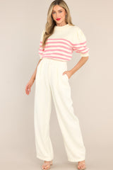 These ivory pants feature a high waist, a zipper closure, belt loops, pelted detailing, and functional pockets. 