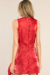 Back view of this dress that features a high neckline, a zipper down the back, a satin like material, and 2 large 3-dimensional bows.