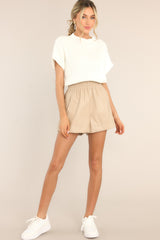 These all beige faux leather shorts feature a high rise, an elastic waistband, functional pockets, and a soft feel inside.