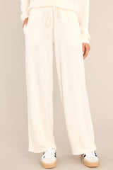 These all ivory lounge pants feature an elastic waistband with a self-tie drawstring, pockets, and a wide leg.