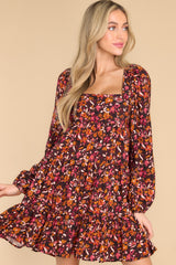 This multi-colored dress features a square neckline, a self tie at the back of the neck, a smocked insert on the back, flowy sleeves with elastic cuffs, and a tiered skirt.