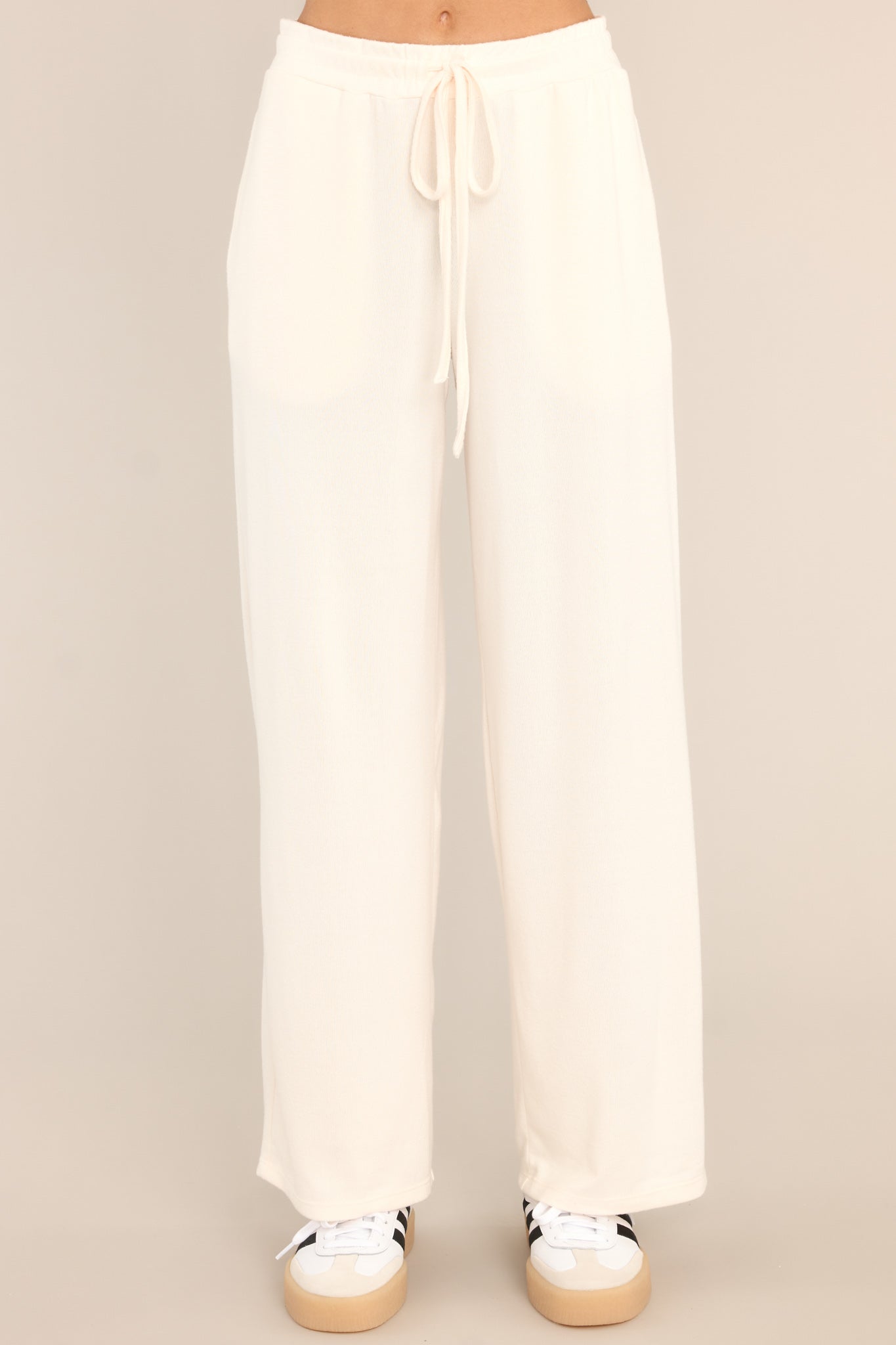 Front view of these lounge pants that feature an elastic waistband with a self-tie drawstring, pockets, and a wide leg.
