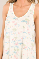 Close up view of this top that features a v-neckline, a tank top design, a soft & lightweight material, a tropical pattern, and a scooped hemline.