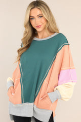 Front view of  this top that features a crew neckline, dropped shoulders, front pockets, a waffle knit material, cuffed sleeves, and a high-low split hemline.