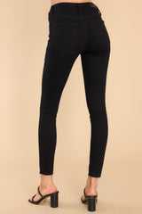 Back view of high waisted black jeans with five functional pockets and belt loops. 