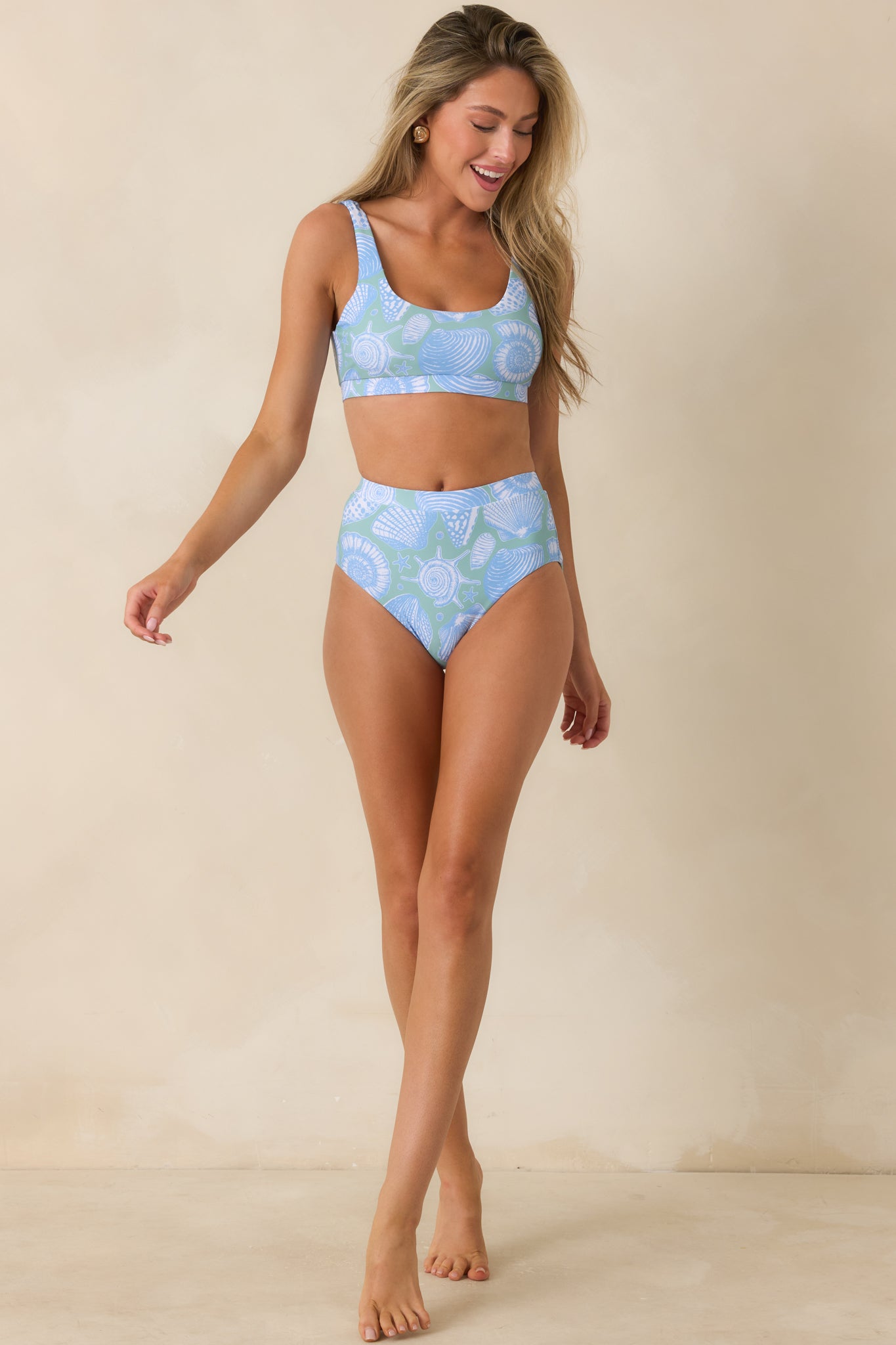 Blue printed swim top featuring a longline fit, scoop neckline, and coastal-inspired seashell pattern.