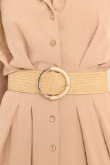 This tan belt features gold hardware, a stretchy band, and a circular buckle with an acrylic accent. 