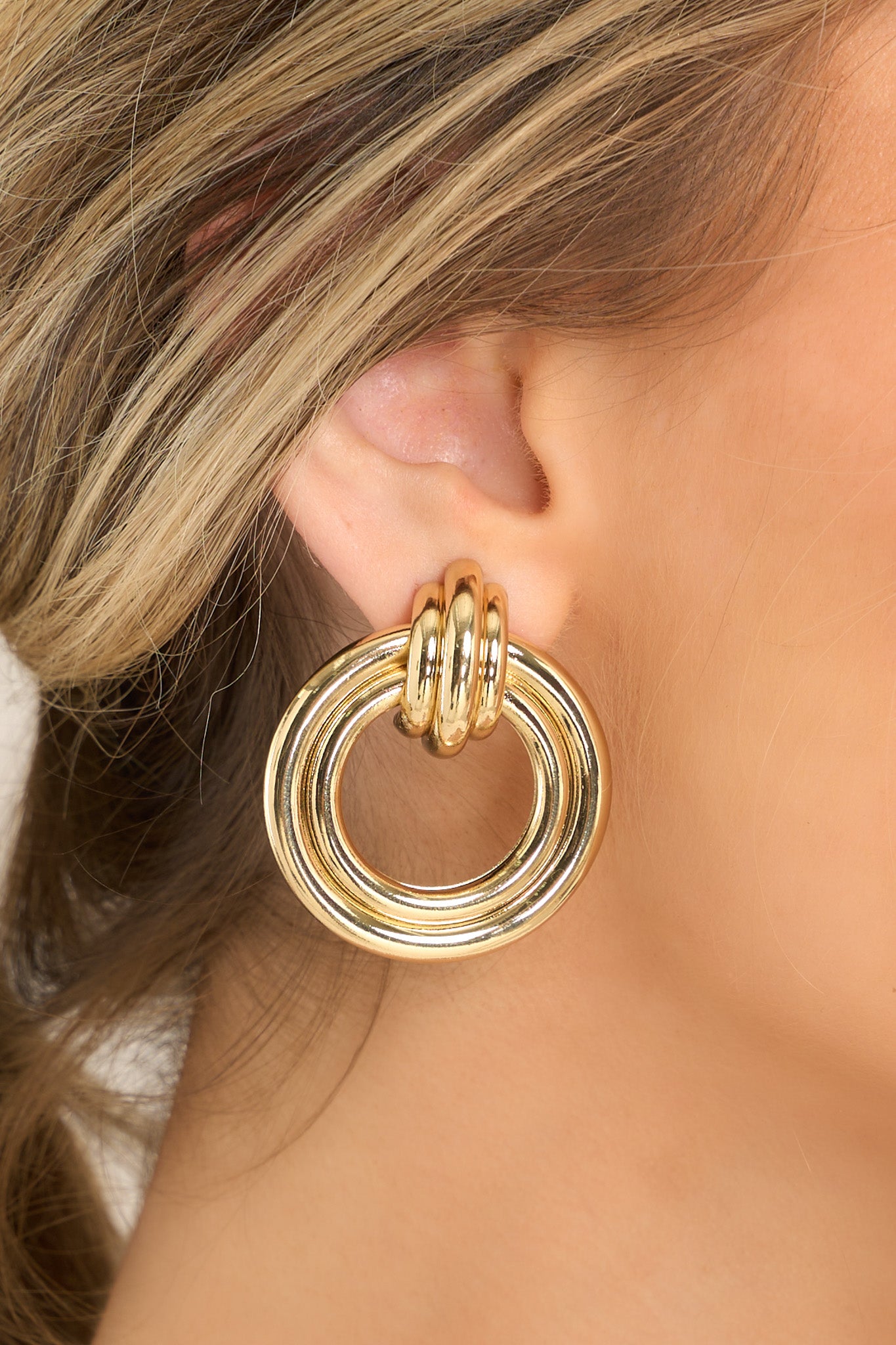 These gold earrings feature gold hardware, a stud with a connected hoop, and secure post backings. 