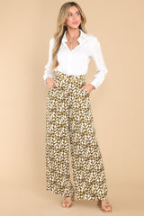 These green pants feature a high rise design, belt loops, a zipper and double hook and eye closures, functional front pockets, and a wide, flowy leg.