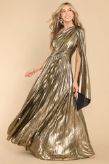 Full view of metallic gold maxi dress with asymmetric neckline, fabric over shoulder, & twisted detailing & pleats throughout.