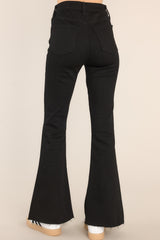 Standard waist down back view of Black Stretch Flare Leg Jeans that feature a raw hemline. 