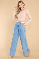 Full body view of these pants that feature a high rise waist, a functional zipper, four functional pocket detailing, and a wide leg with side slits.