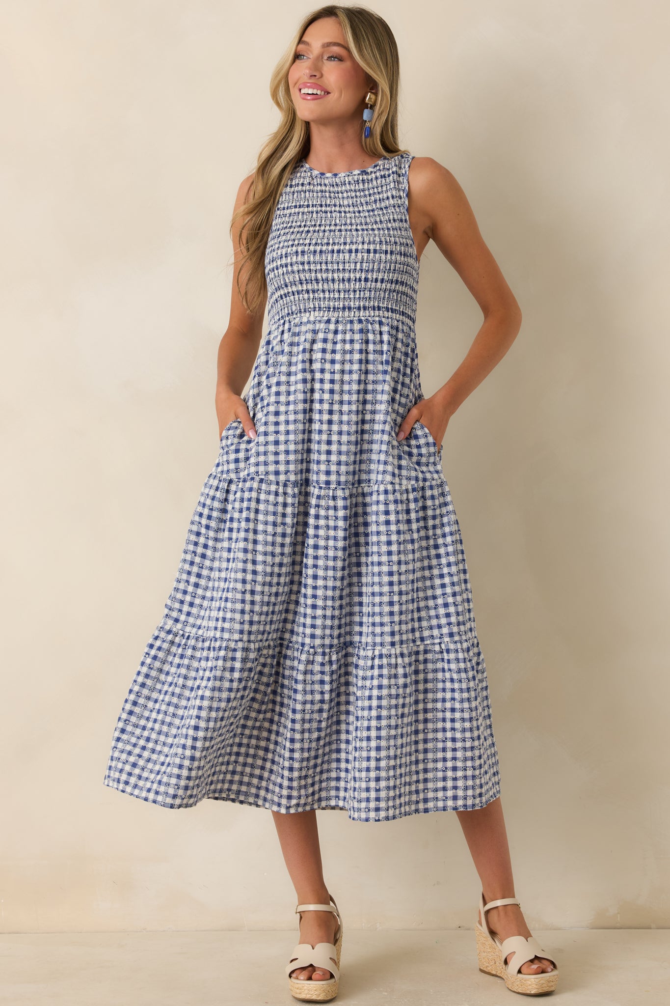 Blue gingham dress showcasing hidden side pockets and a softly flowing tiered design.